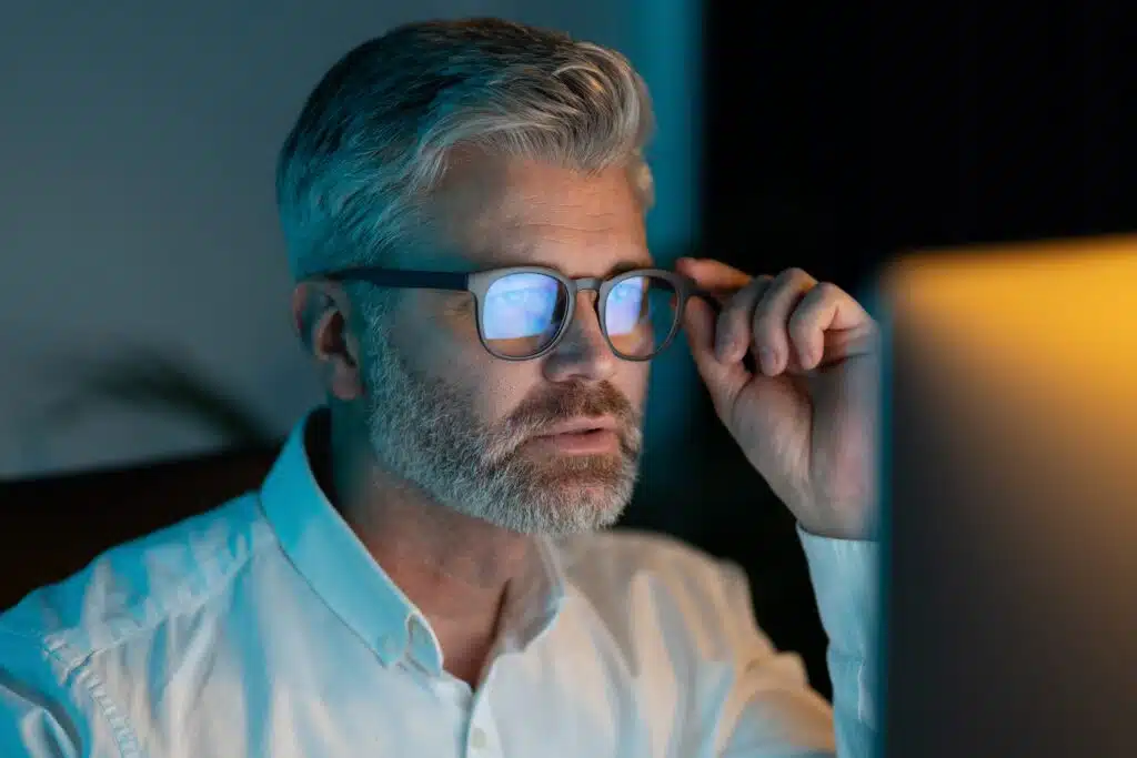 Focused,Mature,Man,Wearing,Glasses,Working,On,Computer,At,Night