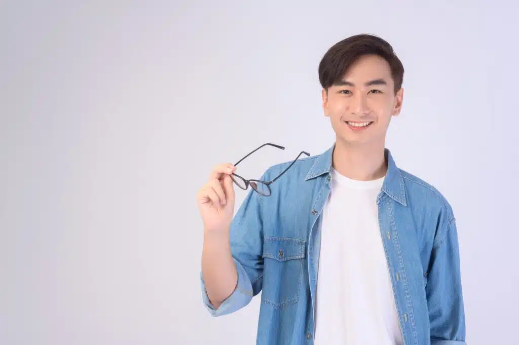A Portrait of asian man taking glasses off with white studio background.