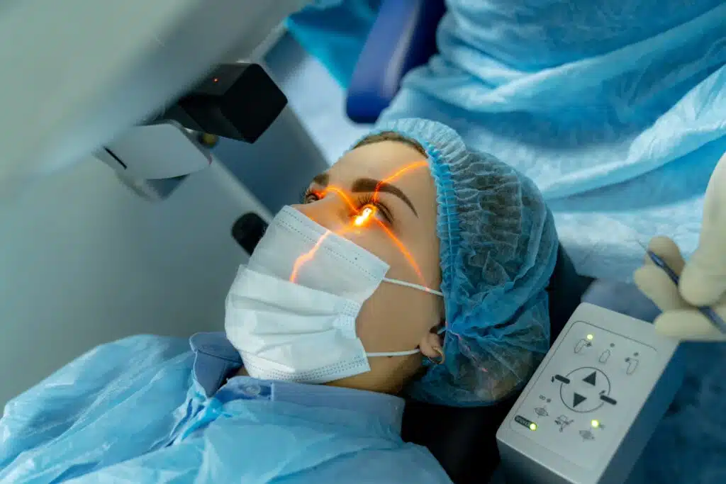 Girl laying on exam table with surgeon positioning machine above her eye
